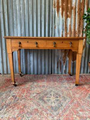 A blonde wood desk on castors