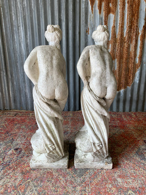 A pair of cast stone Pandora statues