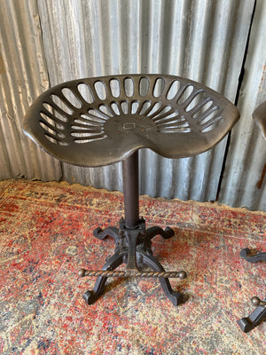 A cast iron adjustable tractor seat stool