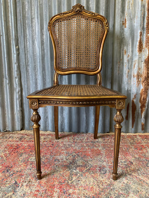 A rococo-style giltwood cane chair