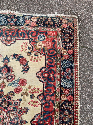 A Persian cream ground rug ~ 194cm x 133cm