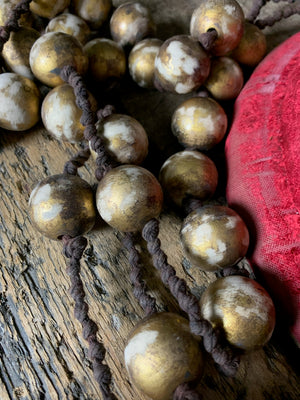 A set of oversized wooden rosary beads with memento mori motif