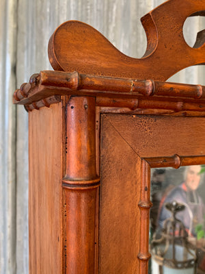 A small French faux bamboo mirrored cabinet