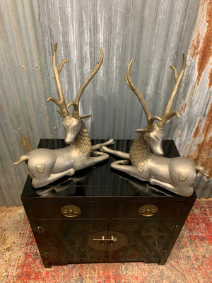 A pair of opposing white metal stags