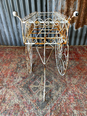 A pair of white wirework barrow plant stands