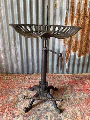 A cast iron adjustable tractor seat stool