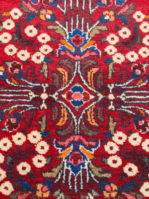 A red ground woolen Persian rug ~ 180cm x 110cm