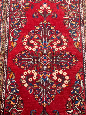 A red ground woolen Persian rug ~ 180cm x 110cm