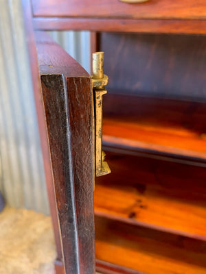 A mahogany double-fronted glass display cabinet with two drawers