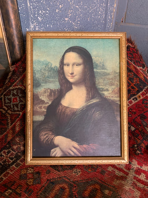A framed oleograph of Da Vinci's "Mona Lisa"