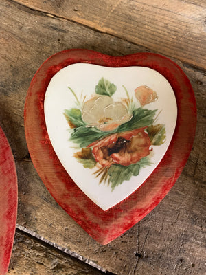 A pair of Victorian porcelain heart plaques on red velvet mounts