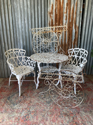 A pair of white wirework barrow plant stands
