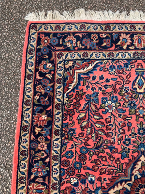 A Persian pink ground wool rug ~ 155cm x 105cm