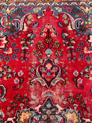 A large red ground Persian rug - 299cm x 194cm