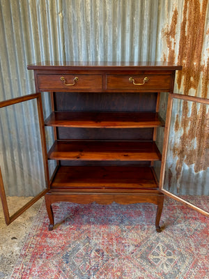 A mahogany double-fronted glass display cabinet with two drawers