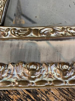 A large brass repousse mirror