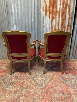 A pair of red damask giltwood open armchairs