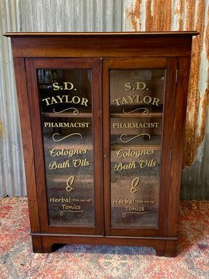 A wooden apothecary style cabinet with glass doors