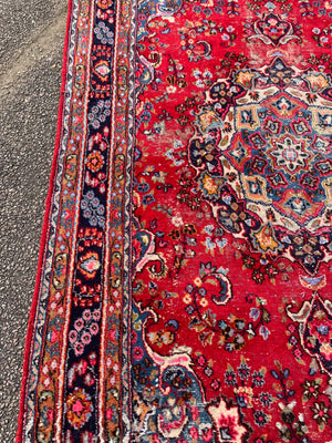 A large red ground Persian rug - 299cm x 194cm