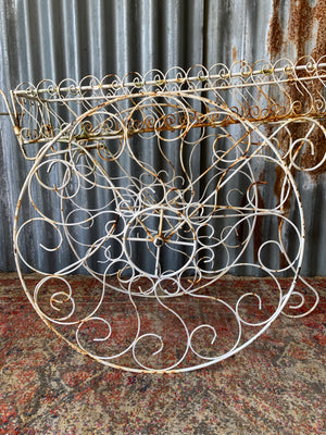 A pair of white wirework barrow plant stands