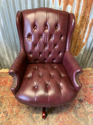 A burgundy leather full button tilt and swivel desk chair