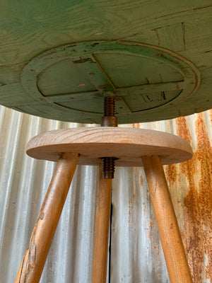 A sculptor's stand with circular oak top