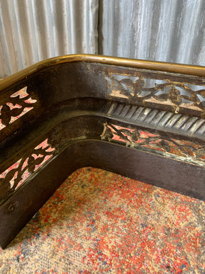 A large Victorian brass fender with lion paw feet