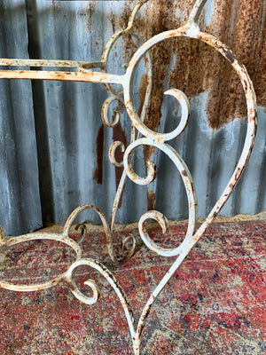 A French-style cast iron garden table with glass top