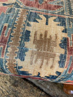 A large kilim-style footstool on cabriole legs