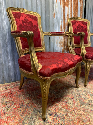 A pair of red damask giltwood open armchairs