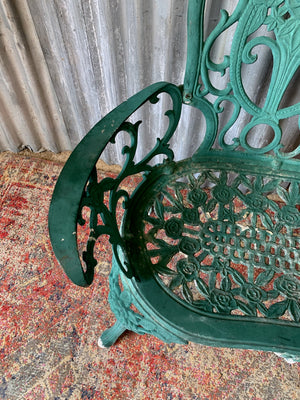 A green cast metal rose motif garden bench