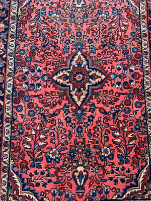 A Persian pink ground wool rug ~ 155cm x 105cm