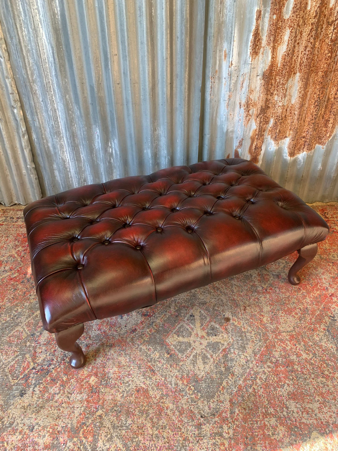A large buttoned oxblood red leather footstool