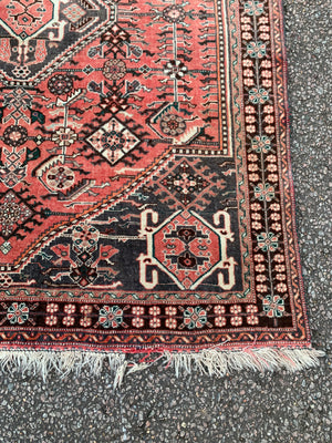 A Persian red ground rectangular rug- 161cm x 117cm