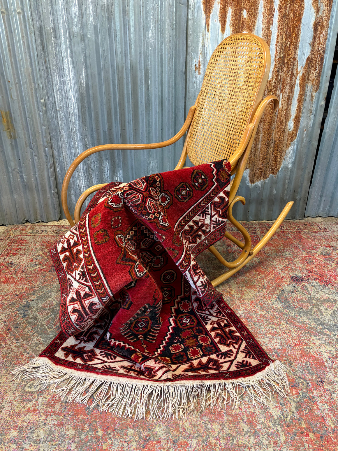 A red ground patterned oriental rug ~ 175cm x 92cm