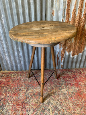 A sculptor's stand with circular oak top