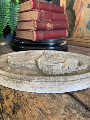 An oval cast stone plaque depicting a dog's head in profile ~A