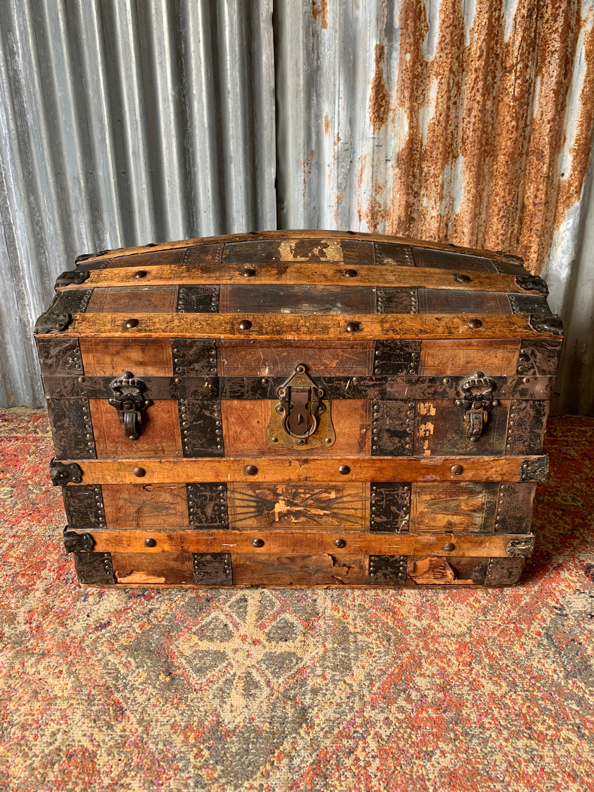 An oak dome top steamer trunk with tooled leather motifs