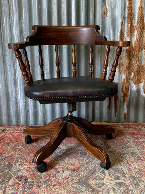 A spindle back captain's desk chair