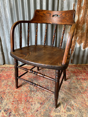 An oak spindle back captain's chair
