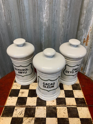 A set of three white ceramic apothecary jars