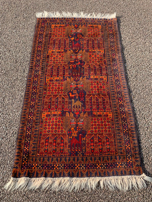 A rectangular red ground Belouch Herat rug depicting lions, camels and birds