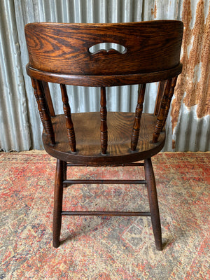 An oak spindle back captain's chair