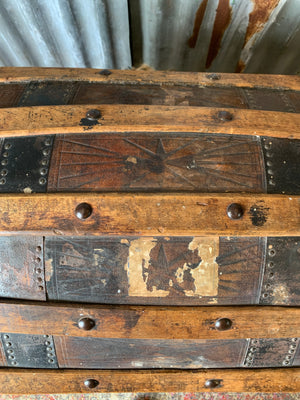 An oak dome top steamer trunk with tooled leather motifs