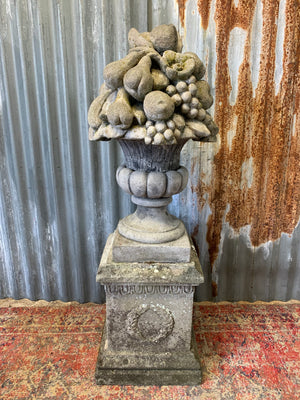 A cast stone cornucopia on plinth