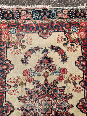 A Persian cream ground rug ~ 194cm x 133cm