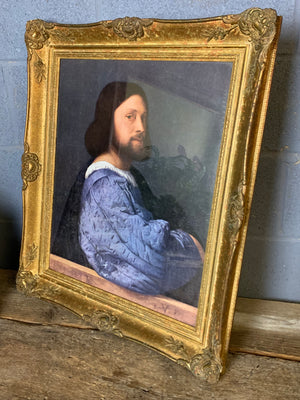A large framed print of Titian's "Portrait of a Man"