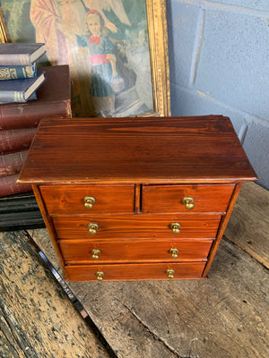 A miniature set of wooden two over three drawers