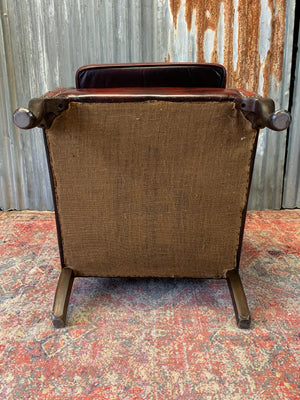 An oxblood wingback Queen Anne-style armchair