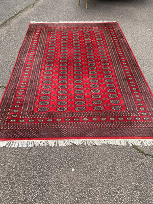 A large red ground Bokhara rectangular rug ~ 282cm x 186cm